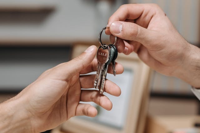 person passing a set of keys to another person