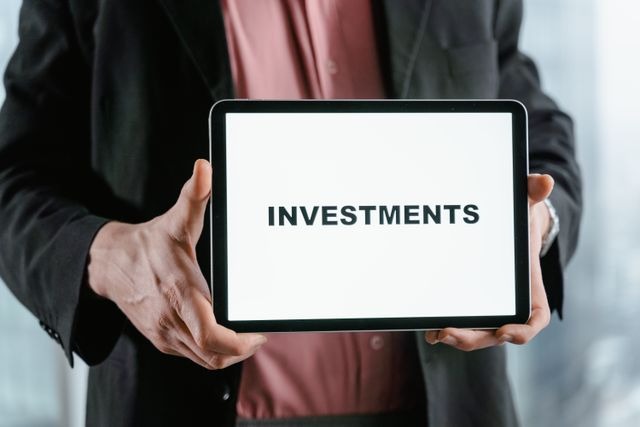 person holding a sign reading investments