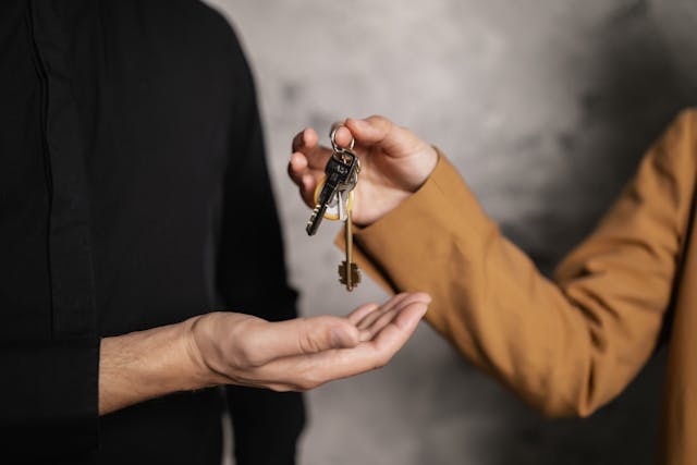 Person Handing Keys to home to another person