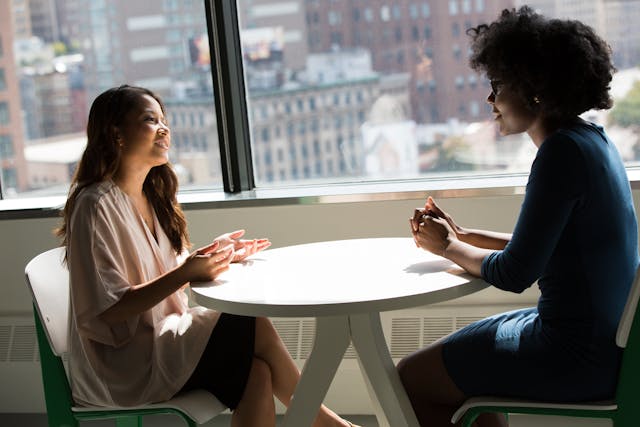 Two people talking over a round table